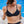 Load image into Gallery viewer, Woman sitting poolside wearing a Bambina Swim black two piece bikini, ring detail on strap, tie back, mid coverage bottom, high cut leg.
