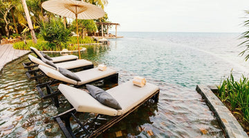 Lounge chairs in infinity pool overlooking ocean