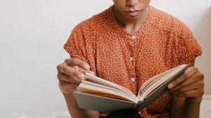 Woman in orange dress reading book
