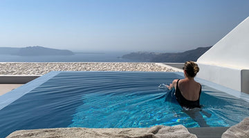 Woman in pool overlooking ocean in Santorini Greece