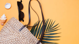 Straw beach bag, sunglasses, and seashells