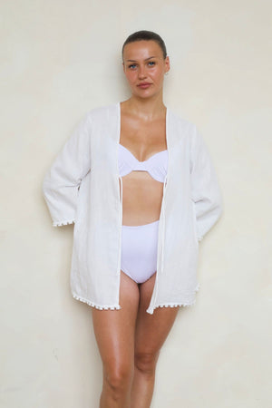 Ava Kimono in White, front view open on model wearing over bikini showing relaxed fit, tie front, tassel trim detail.