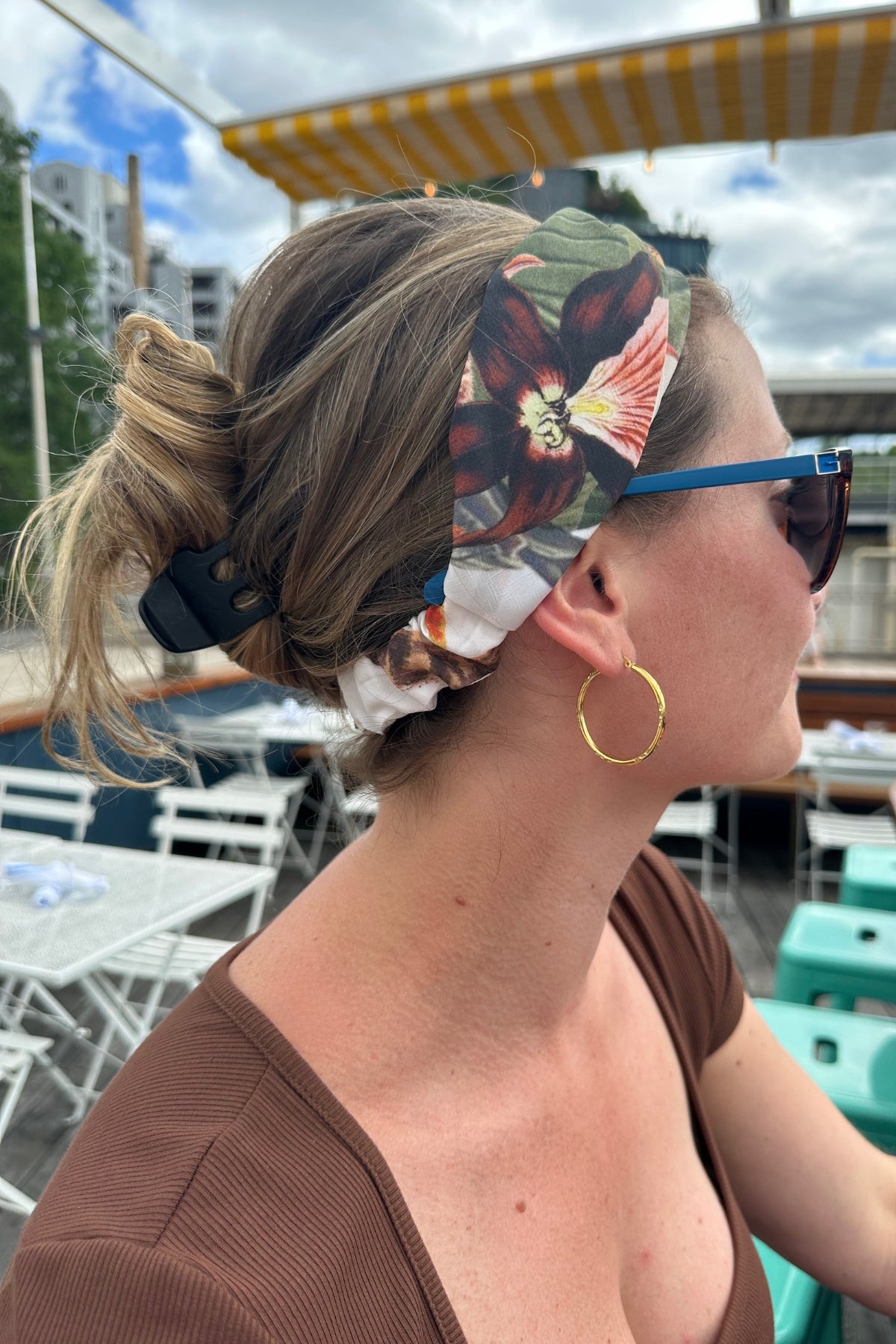 Model wearing Bambina Swim Cardamom headband in tropical print, side view showing bottom elastic detail and print placement.