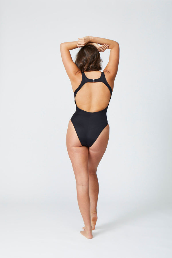 Back view of a women wearing a black one piece swimsuit