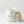 Candle with a label and wooden lid on a light gray background