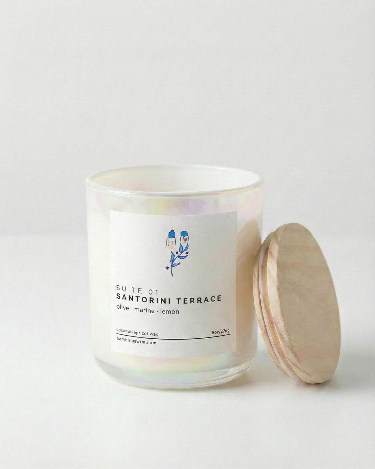 Candle with a label and wooden lid on a light gray background