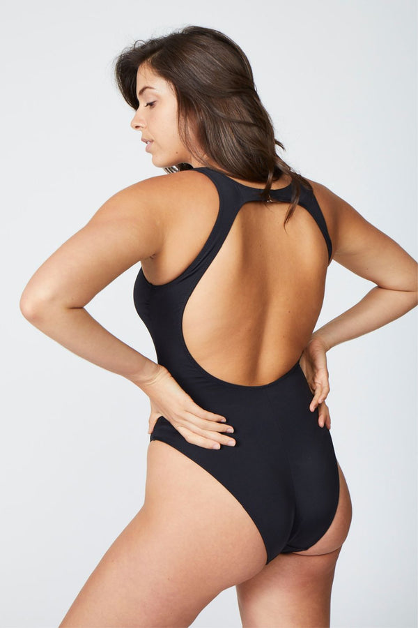 Side view of a woman wearing a black one piece swimsuit
