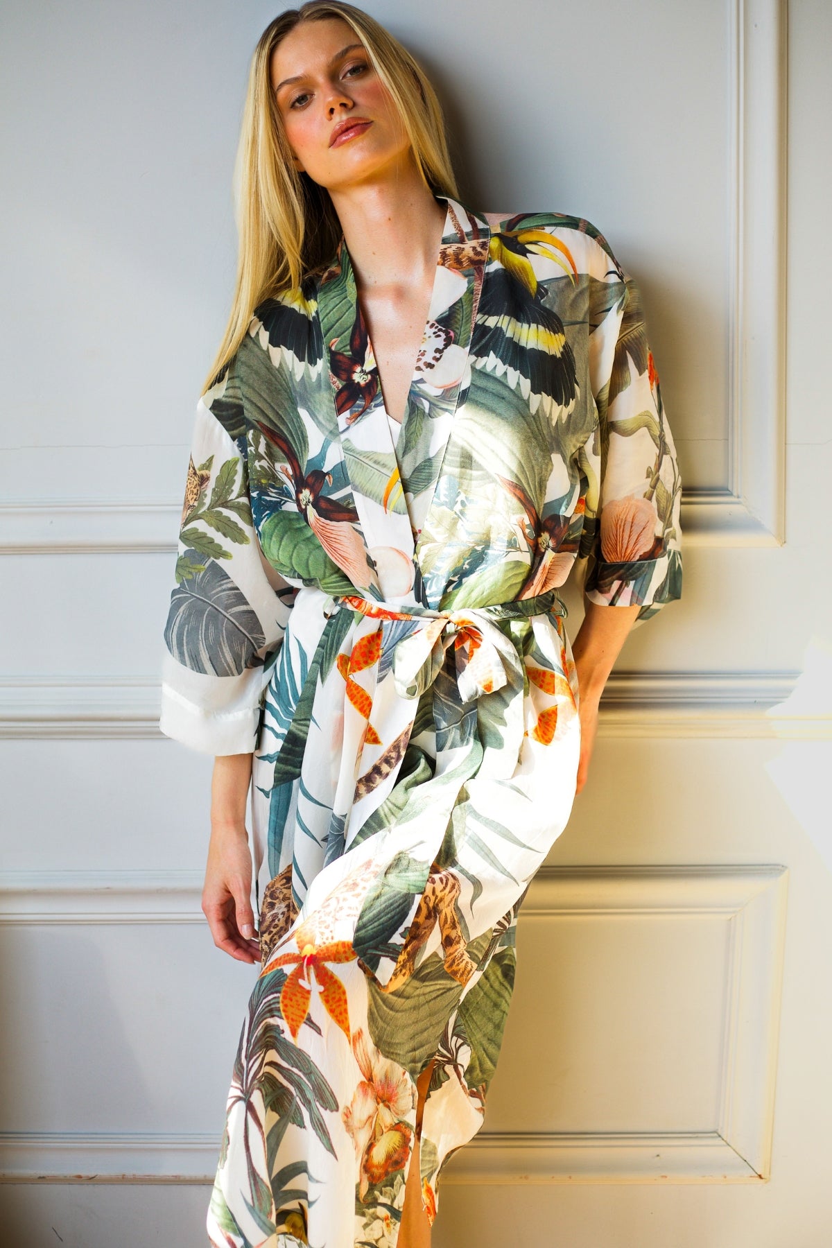 Model wearing Bambina Swim Cardamom robe in tropical print, front view showing relaxed fit and belted waist.
