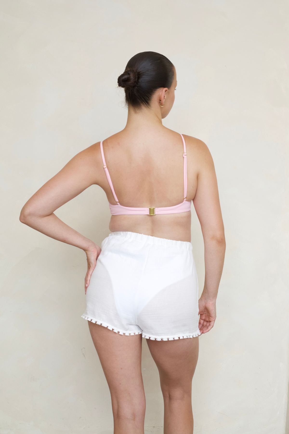 Bambina Swim Rebecca Shorts in white, back view on model, showing elastic waistband, and tassel trim detail.