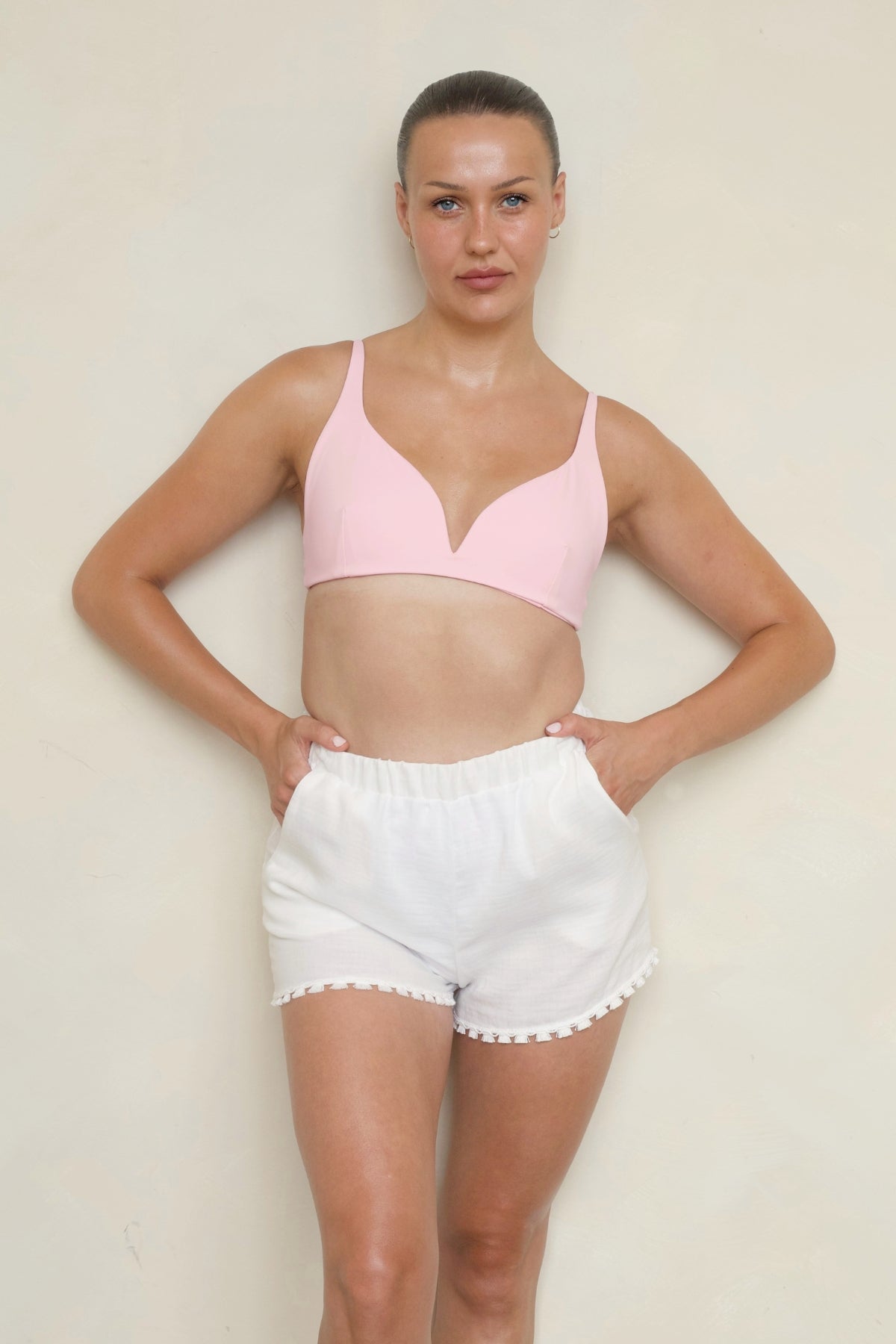 Bambina Swim Rebecca Shorts in white, front view on model showing elastic waistband, side pockets, and tassel trim detail.