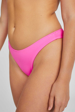 Close up of woman wearing a bright pink bikini bottom. Mid coverage bottom, high cut leg. 